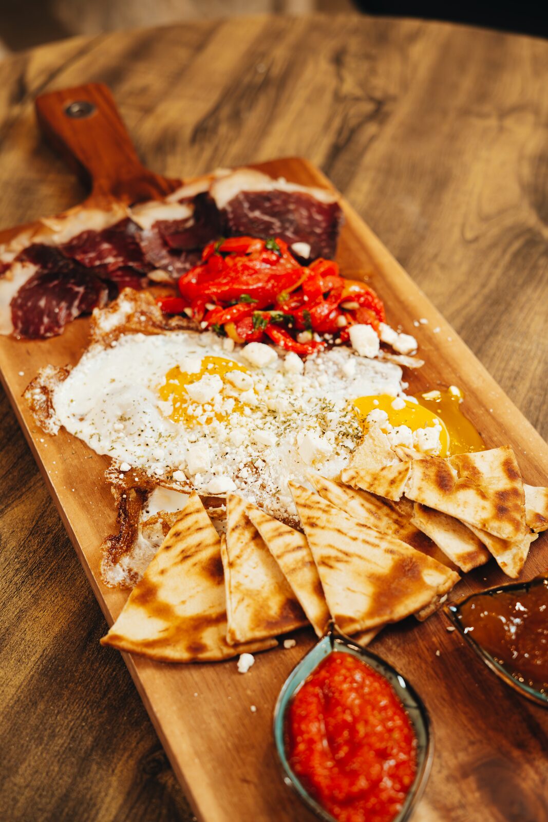Mediterranean breakfast board with eggs, meats, peppers, pita