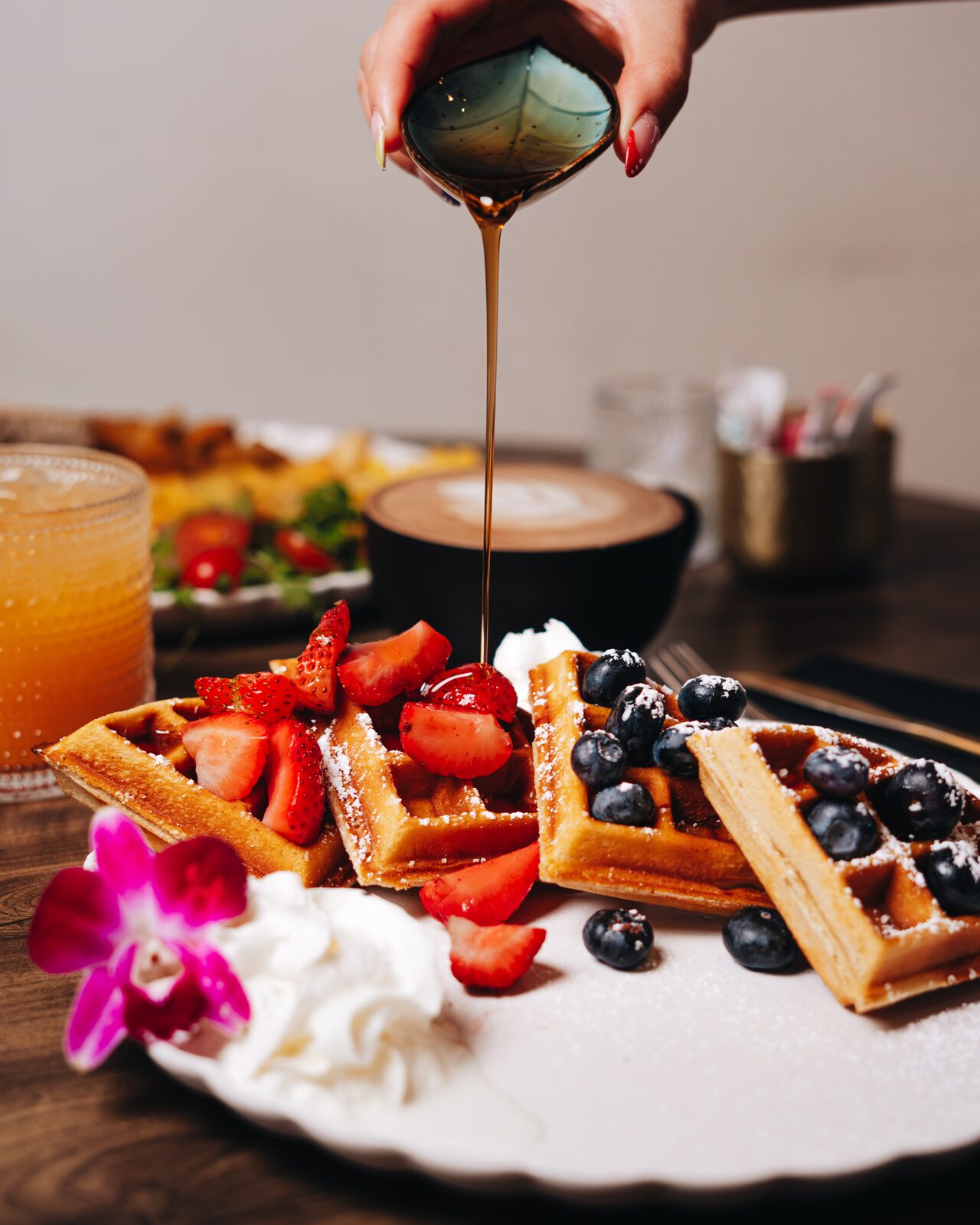 Waffles with fresh berries and maple syrup pour